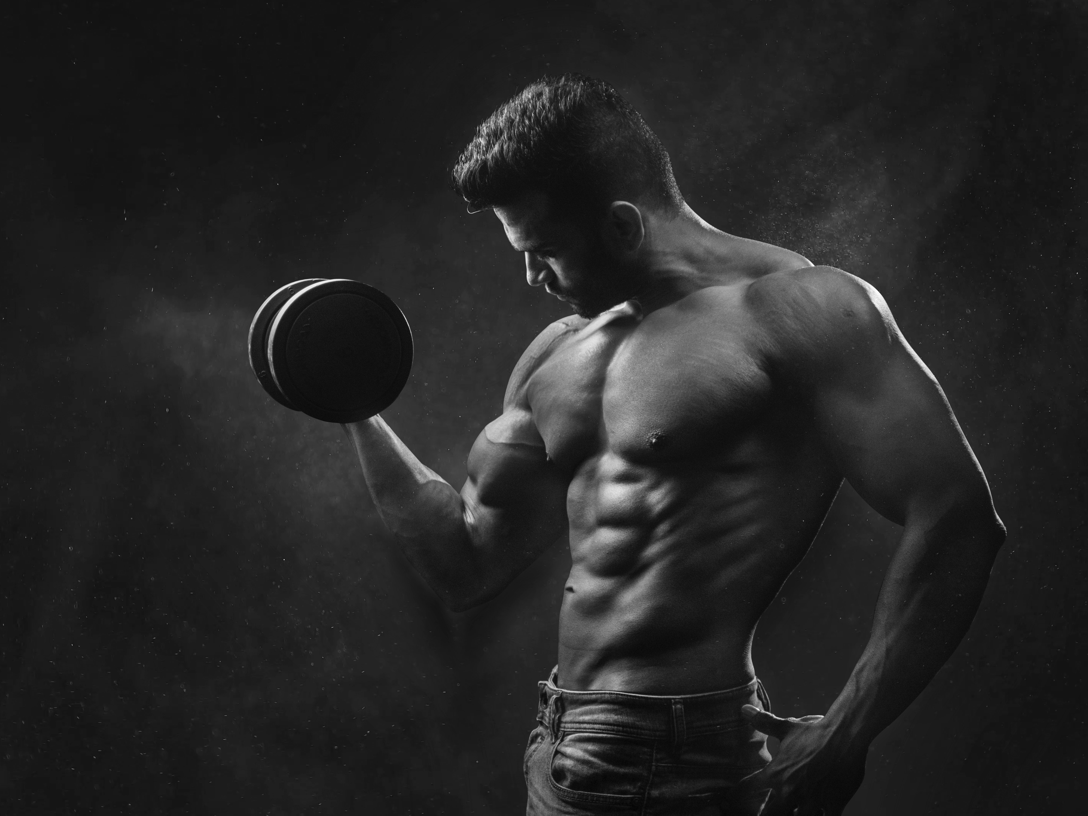 Imagem de um atleta sem camisa mostrando os músculos através do exercício rosca direta com um halter relativamente grande